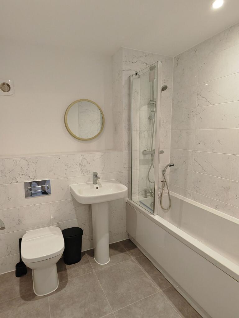 A modern bathroom suite featuring a clean white...
