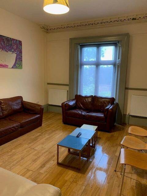 A cozy living room featuring warm wooden floors...