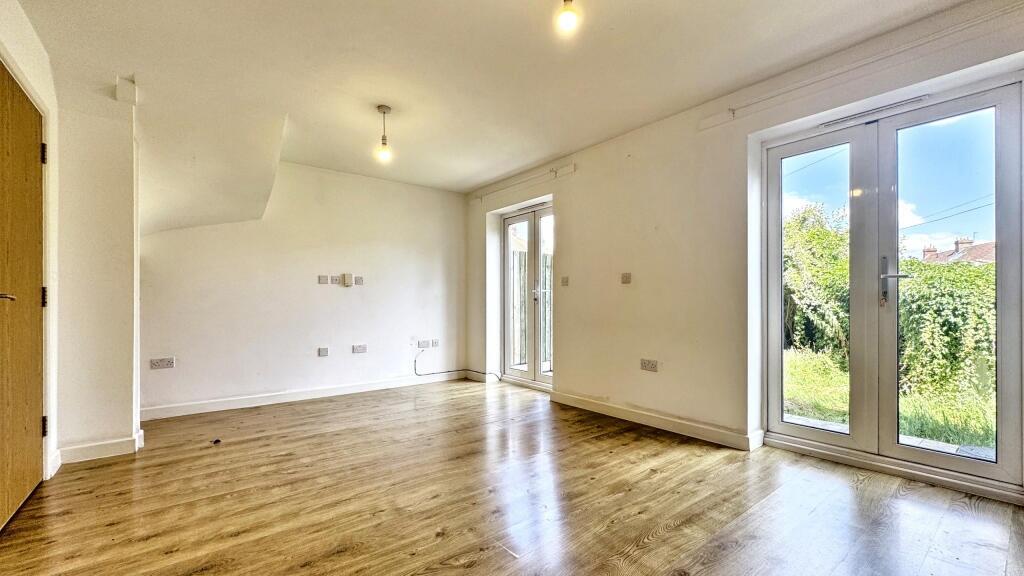 Bright and spacious living room featuring large...