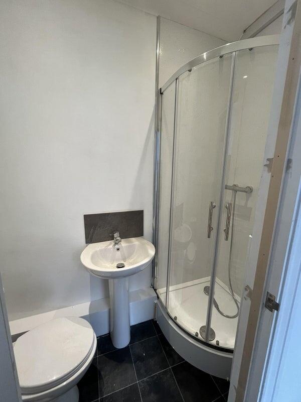 A well-maintained bathroom featuring a curved g...