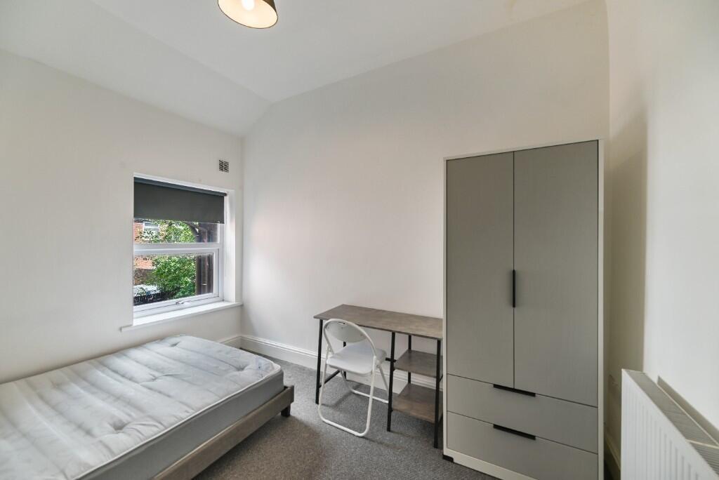 A bright and neat single bedroom featuring a co...