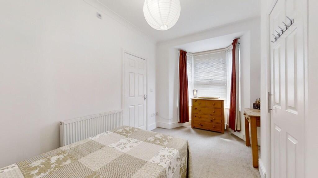 A neat and tidy single bedroom with a bright wi...