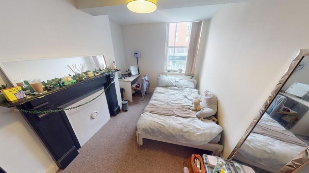 A cozy double bedroom featuring two single beds...