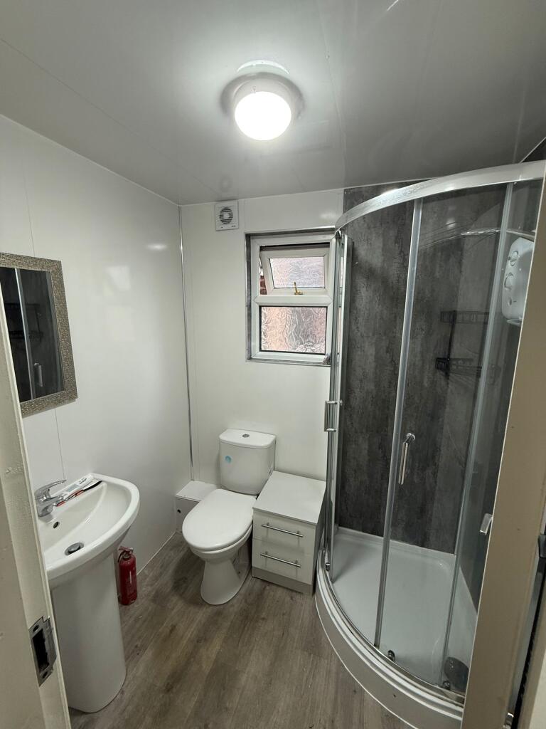 A modern, clean bathroom featuring a curved gla...