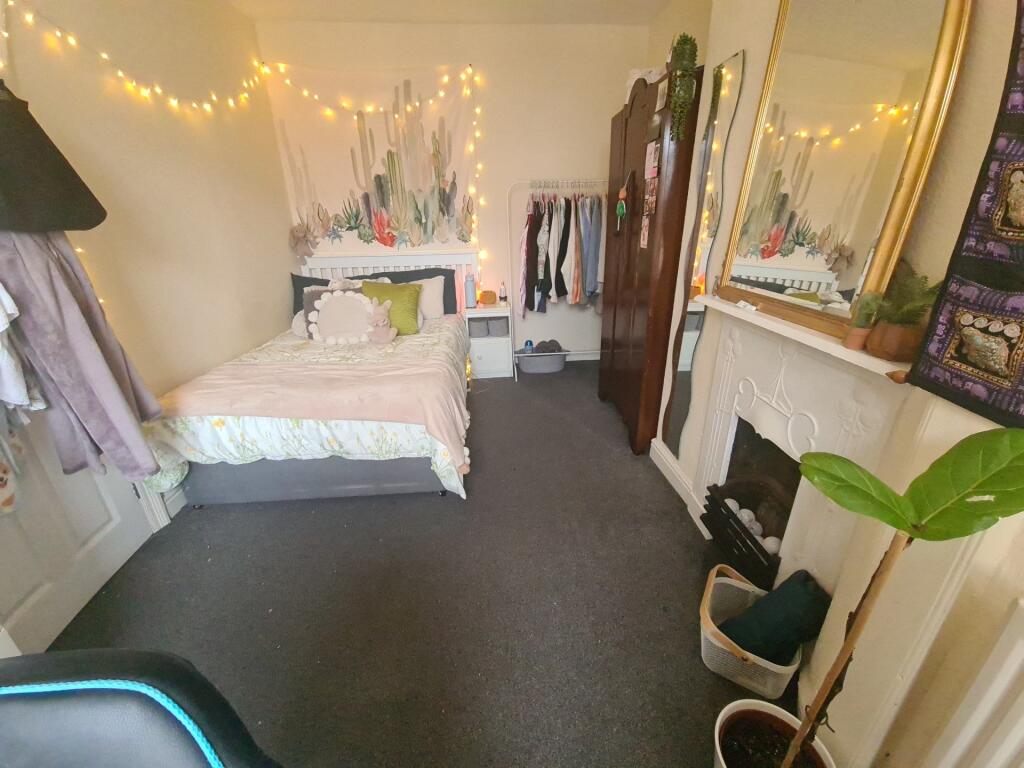 A charming and spacious bedroom featuring a com...