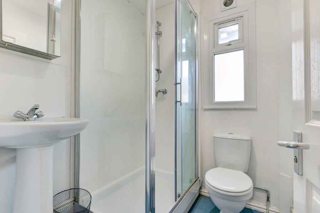 A bright, modern bathroom featuring a clean whi...
