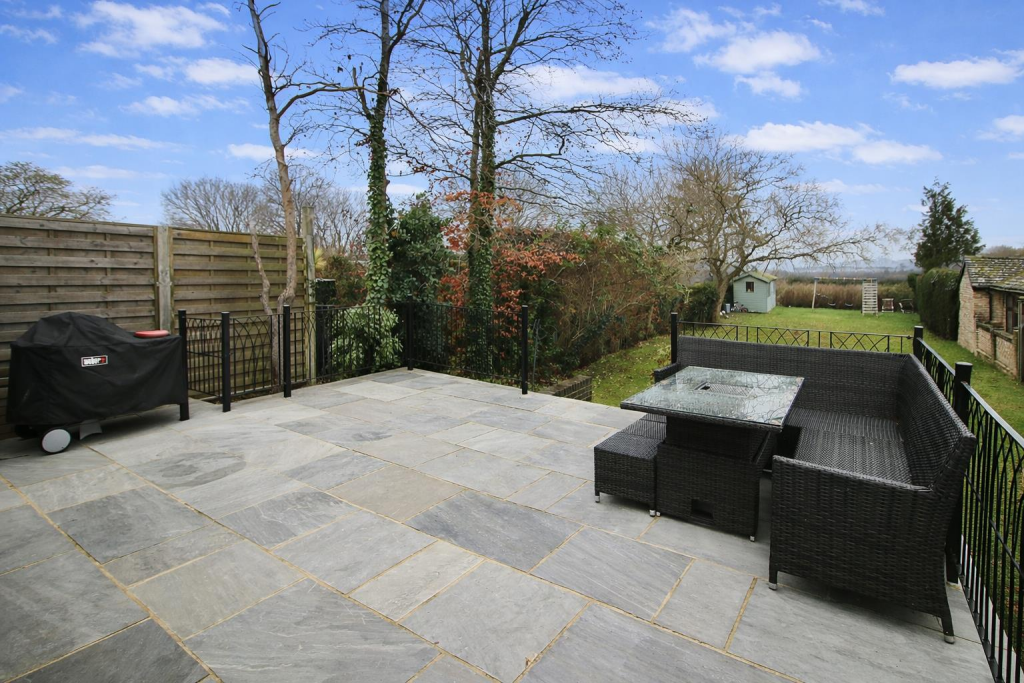 Sunny garden patio with rattan seating.png