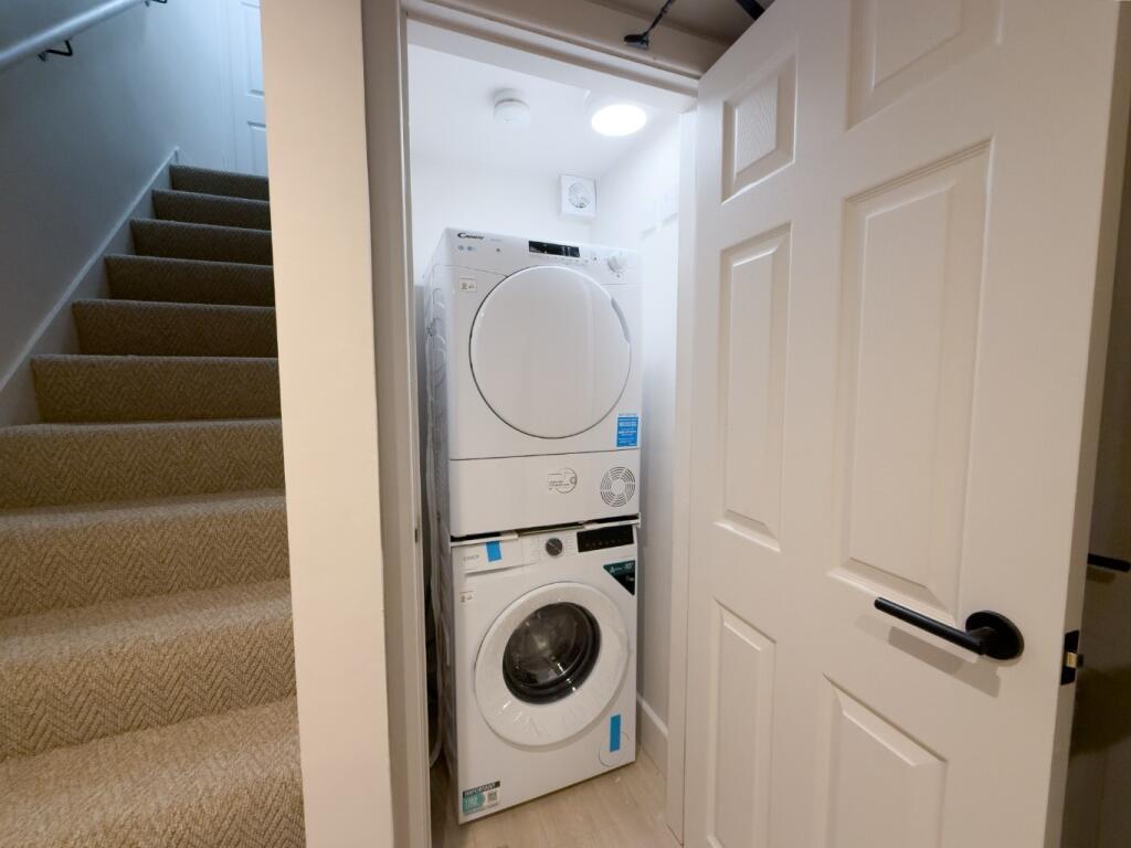 Neat built-in utility cupboard with stacked was...