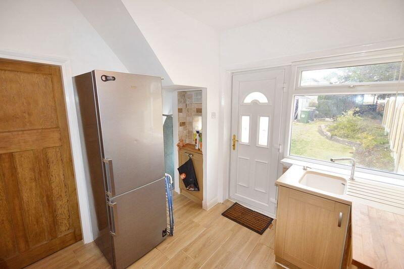 Bright and tidy kitchen featuring modern wooden...