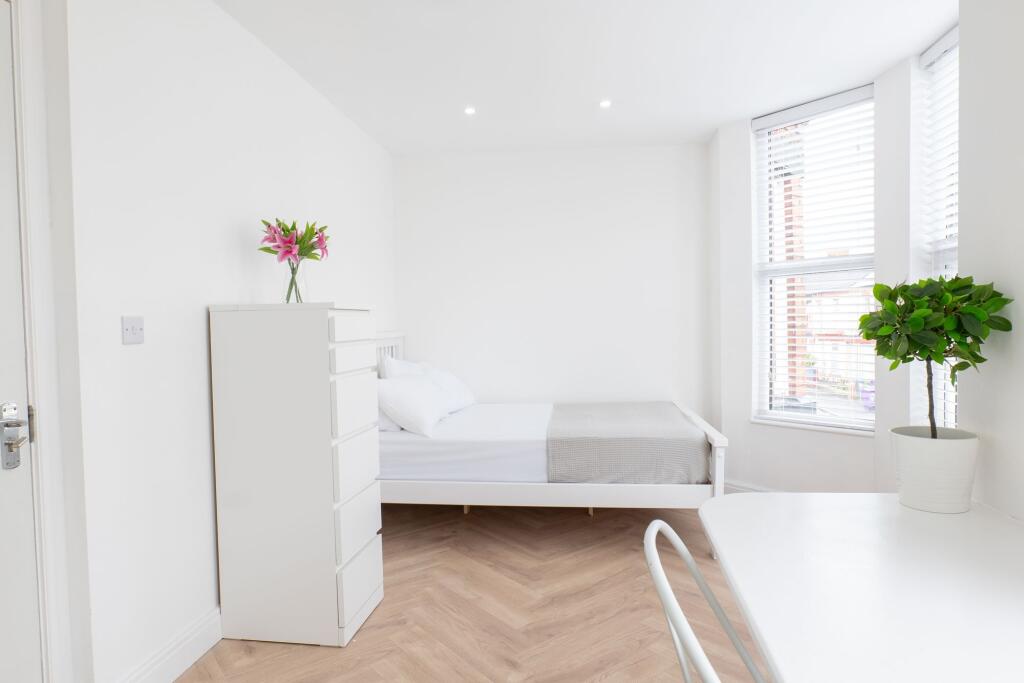 Bright and minimalistic master bedroom with a w...