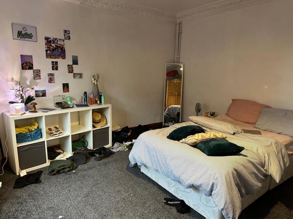 A cozy bedroom featuring a double bed with pill...