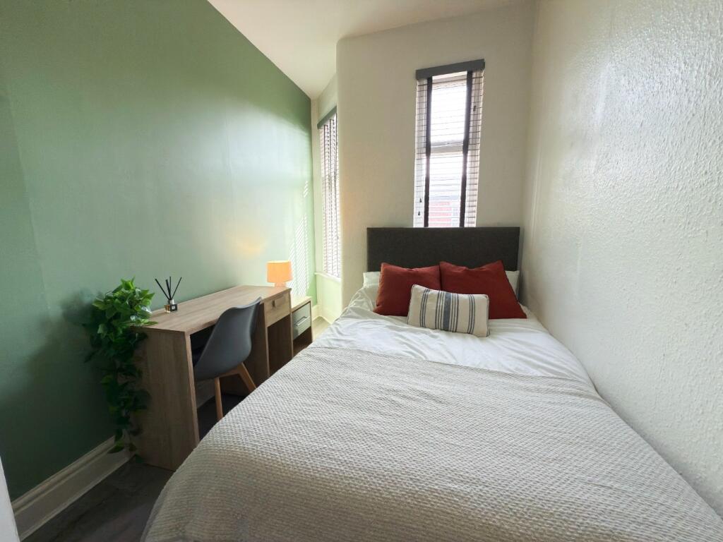 Bright, neatly presented bedroom with a comfort...