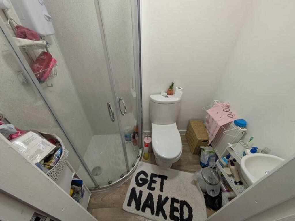 A compact bathroom featuring a shower, offering...