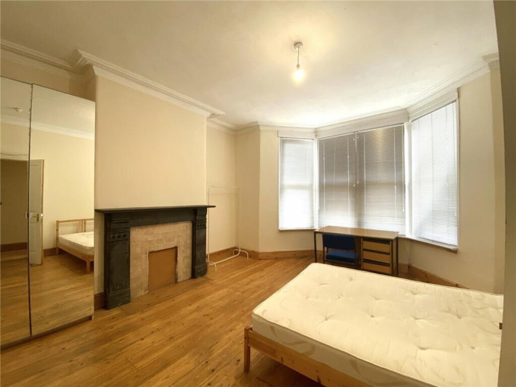 This spacious double bedroom features large win...