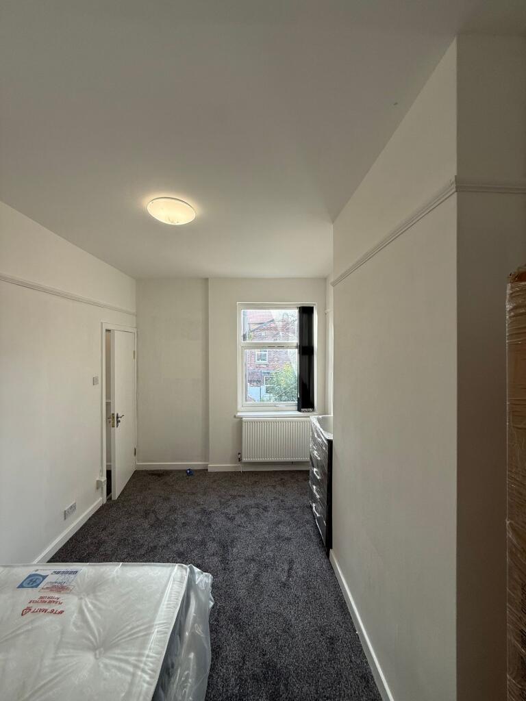 Bright and clean bedroom featuring a window pro...