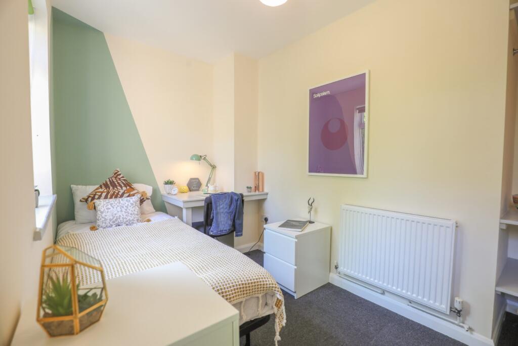 A bright and modern bedroom featuring a cozy be...