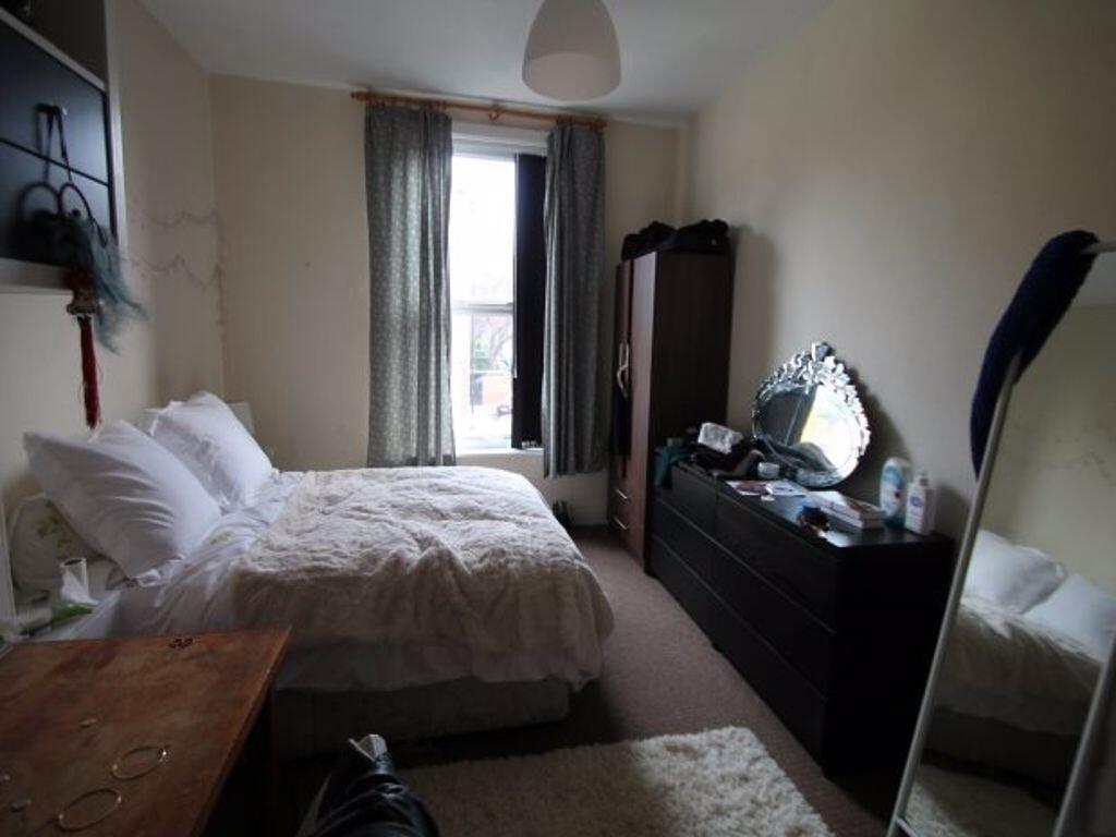 Bright and cozy master bedroom featuring a comf...