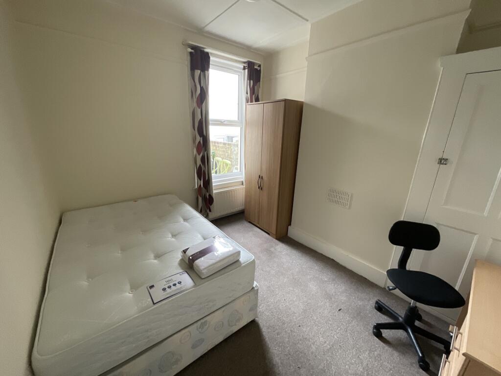 A bright and tidy bedroom featuring a single be...