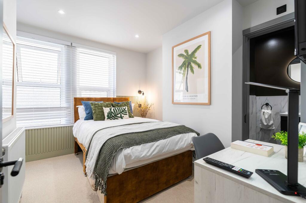 Bright and modern bedroom featuring a cozy doub...