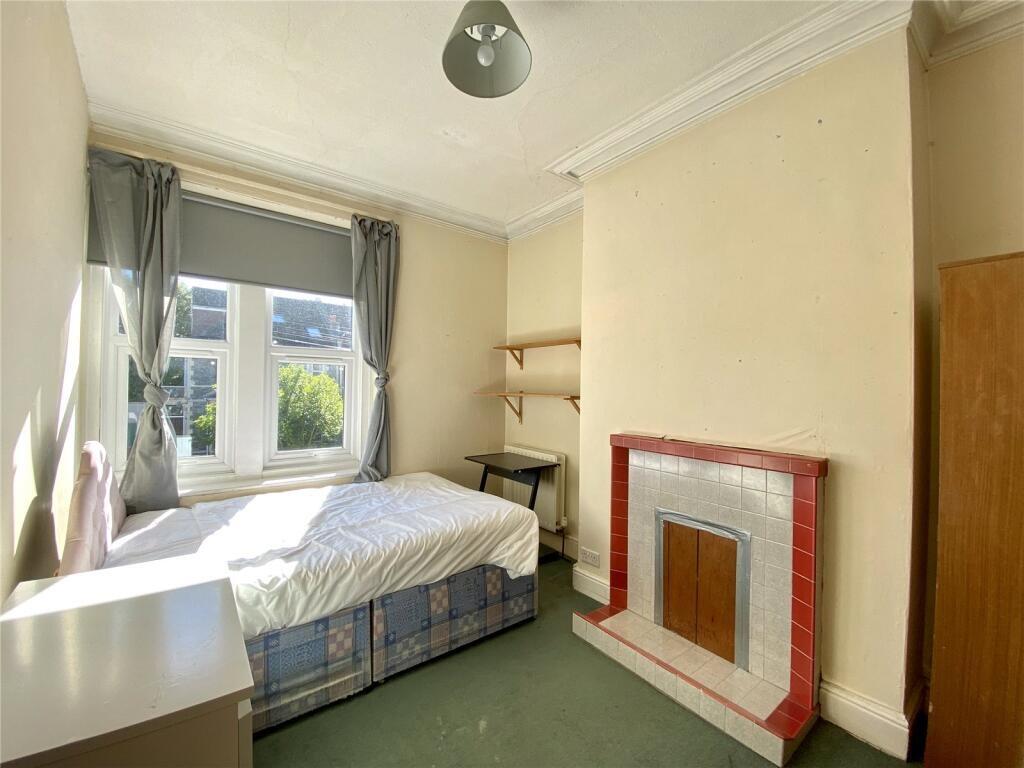 Bright single bedroom with a large window allow...