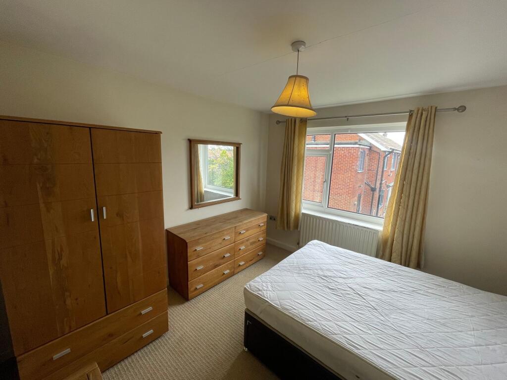 Bright and airy bedroom featuring a large windo...