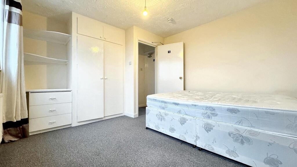 Spacious double bedroom featuring ample natural...