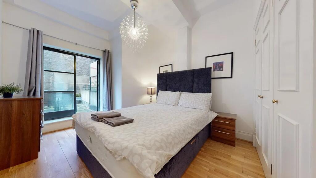 A bright and stylish master bedroom featuring a...