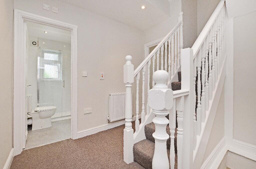 A bright and clean hallway featuring a white ba...