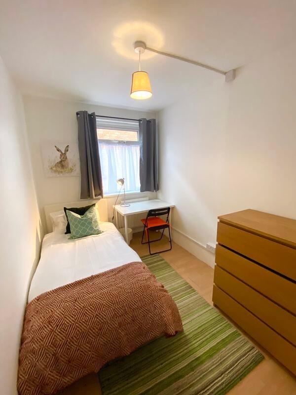 This cozy single bedroom features a comfortable...