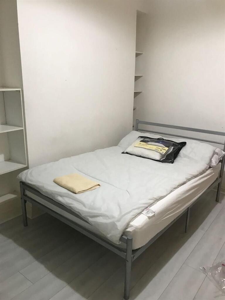 A clean and neatly arranged bedroom featuring a...