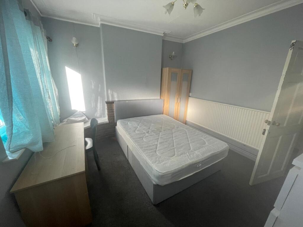A cozy single bedroom featuring a double bed, a...
