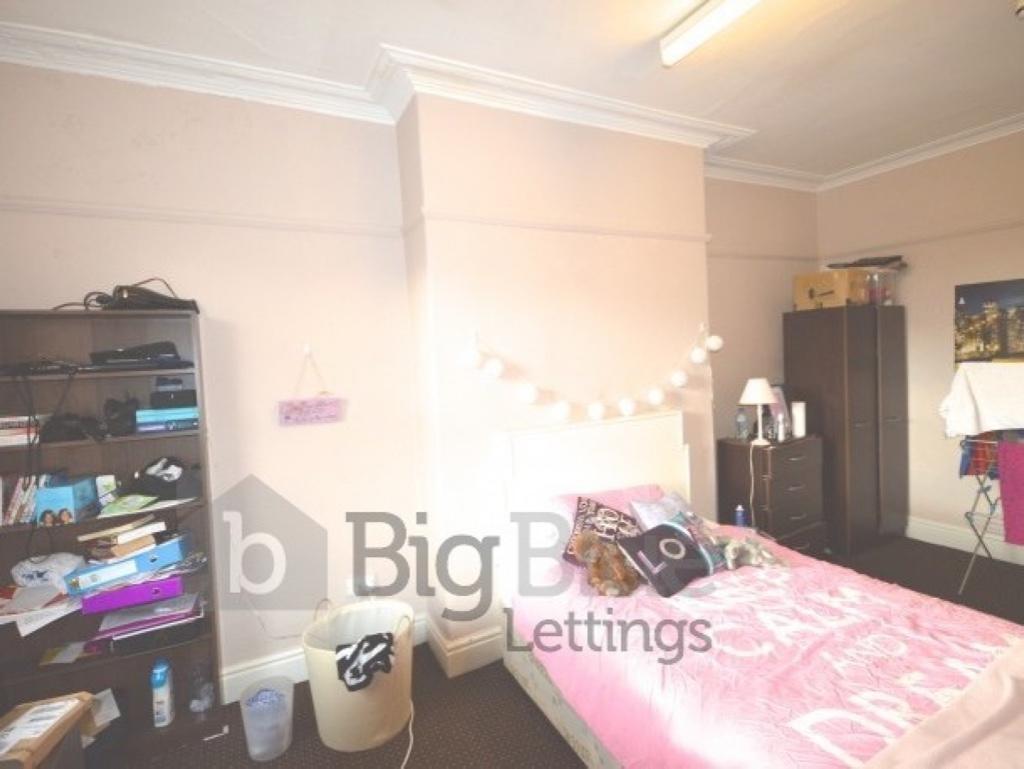 Cozy bedroom featuring a comfortable bed with p...