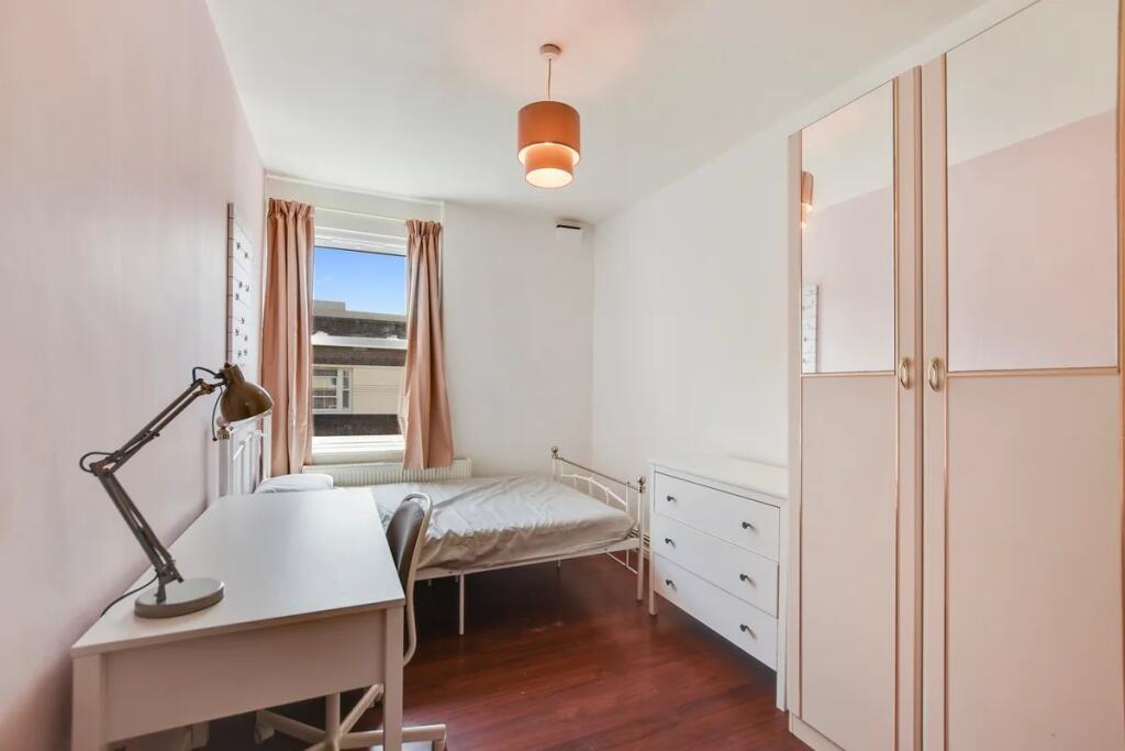 A neat and bright single bedroom featuring a wh...
