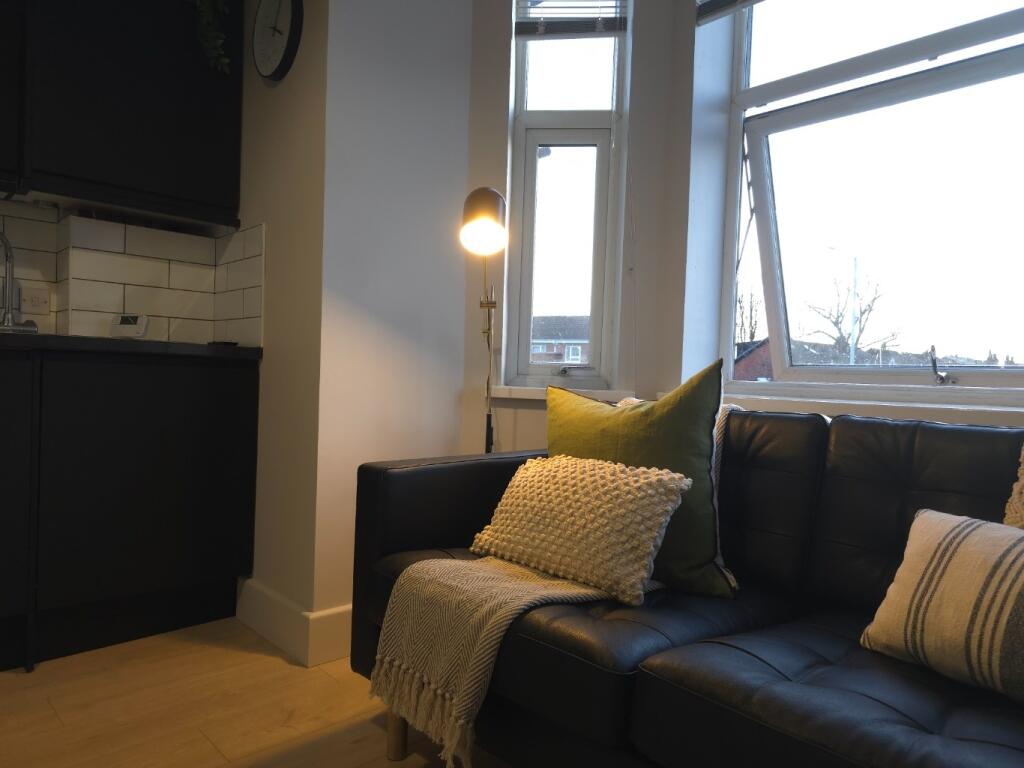 Cosy living area with a dark leather sofa dress...