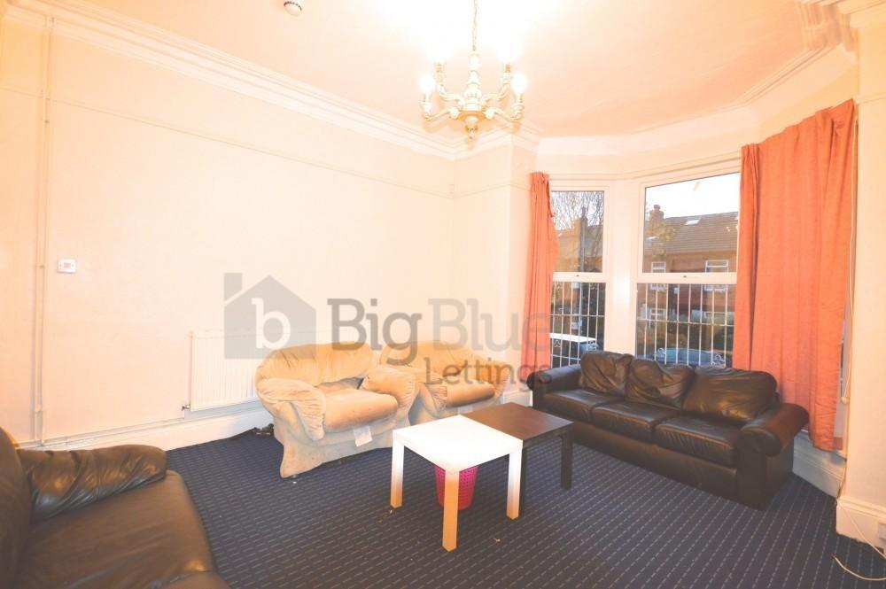 A cozy living room featuring a bay window with ...