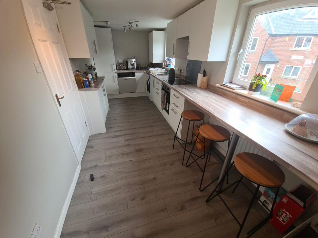 Bright and modern kitchen featuring a long brea...