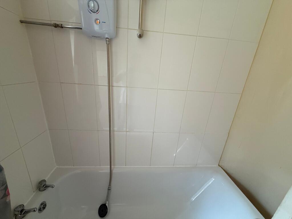 Bright, tiled bathroom with a built-in bathtub ...