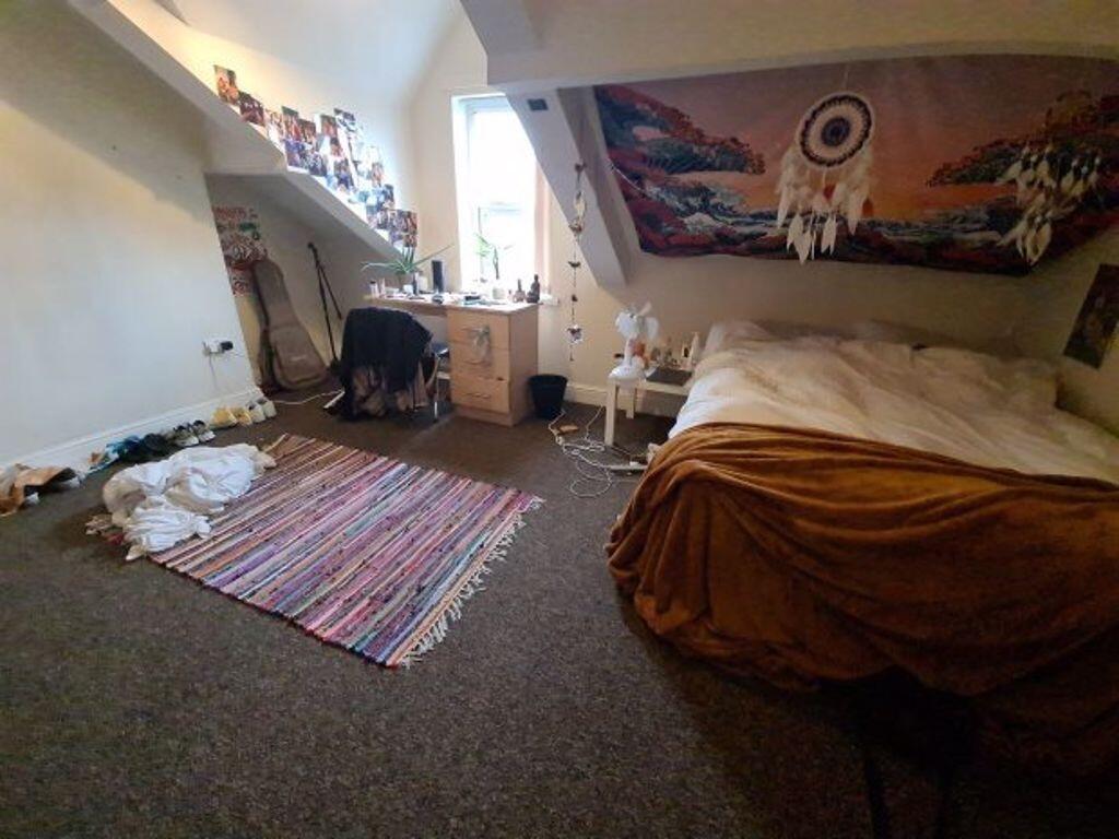 Cozy attic bedroom with sloped ceilings, a comf...