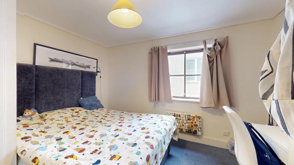 A comfortable double bedroom with a colorful pa...
