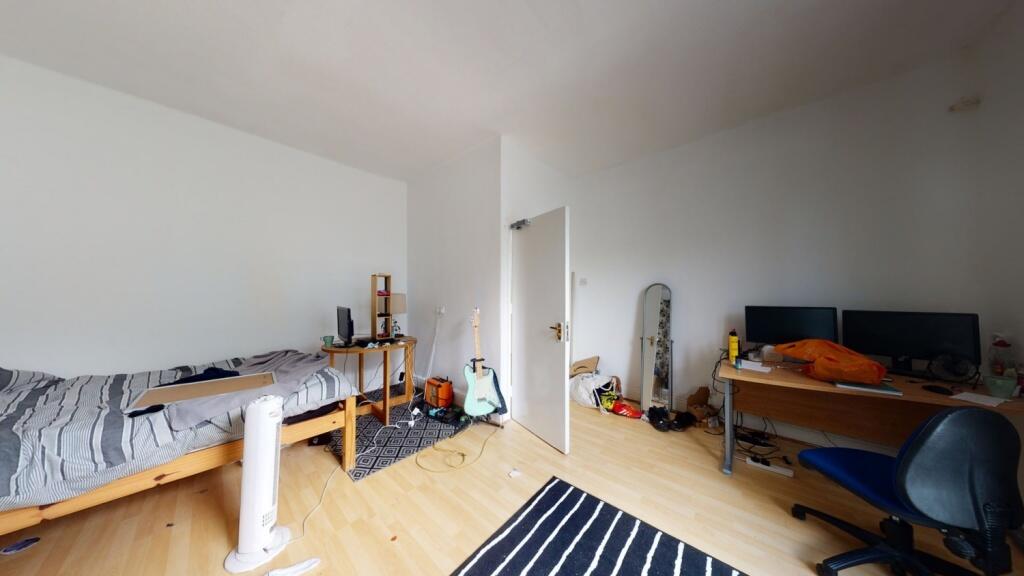 A bright and tidy single bedroom featuring a wo...