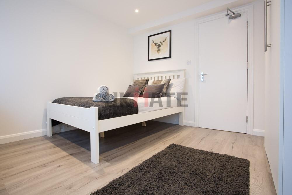 A well-maintained, bright bedroom featuring a w...