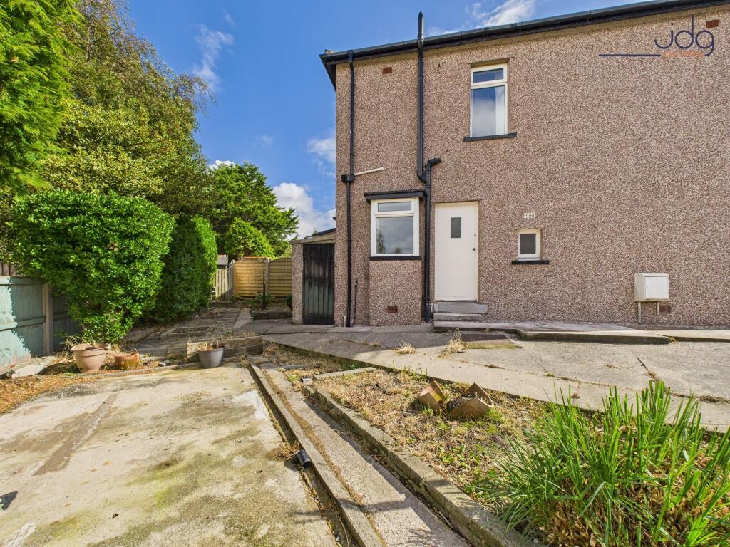 Wrap around garden to the side and the front with mature plant beds, flags and lawn