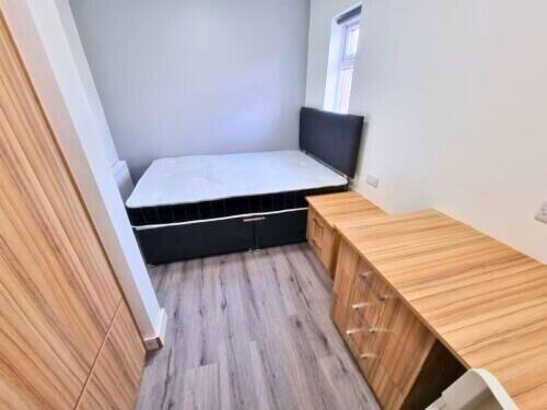 A neat and well-organized single bedroom featur...