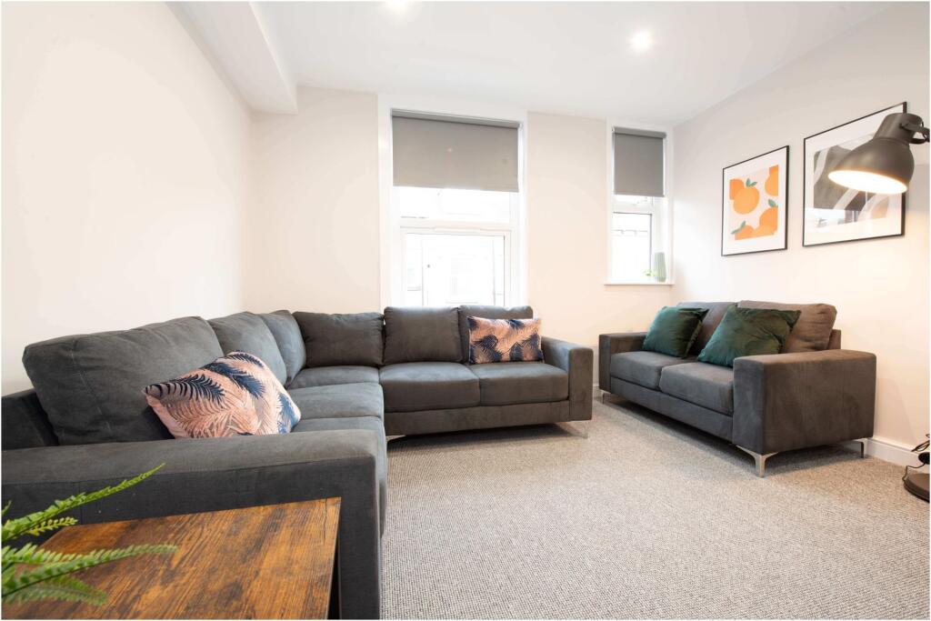 A spacious, modern living room featuring comfor...