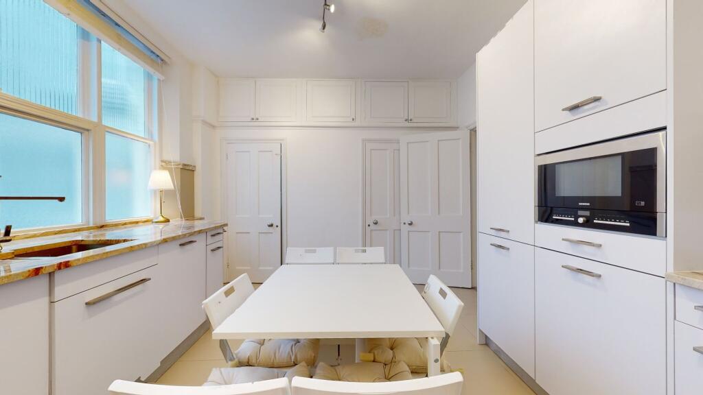 Bright and modern kitchen featuring sleek white...