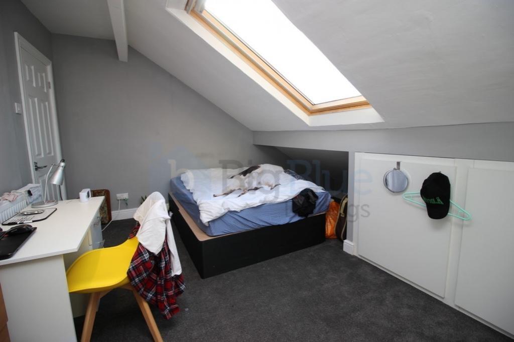 Bright small room with sloped ceiling and skyli...
