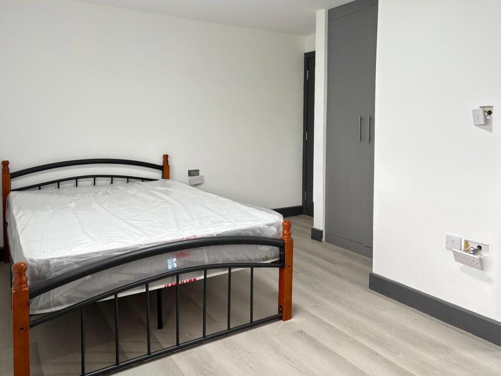 Neat, simply furnished bedroom with a double me...