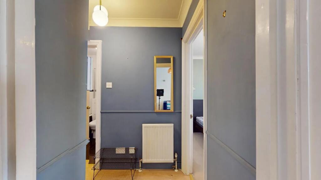A neat hallway painted in a calming blue hue wi...