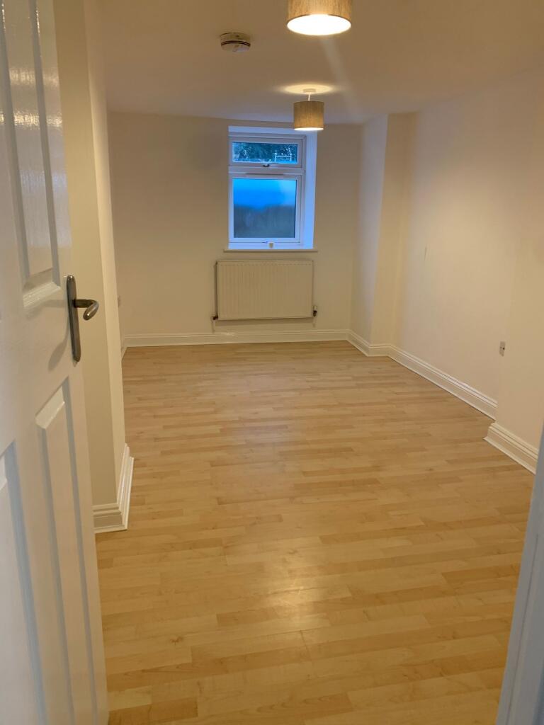 A clean and fresh single bedroom with light woo...