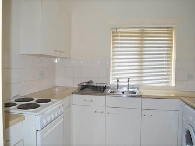 Bright and functional kitchen featuring white c...